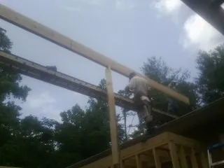 Carpenter setting a ridge beam over a new addition frame — Ice Dam Removal by Roofing Brothers in Orland Park