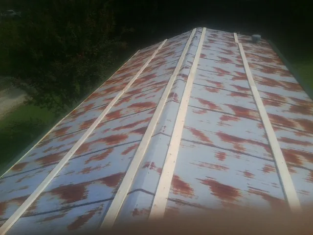 Rusted metal roof panels with new wood purlins before replacement — Storm Damage Roof Repair in Orland Park by Roofing Brothers