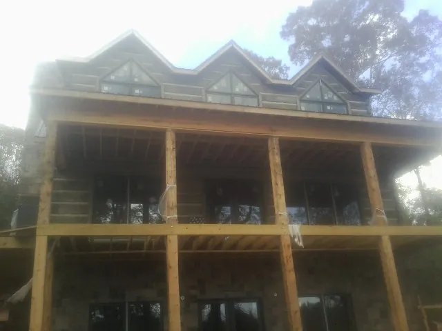 Dormers and porch framing on a large log home under construction — Roof Coating work by our crew in Orland Park