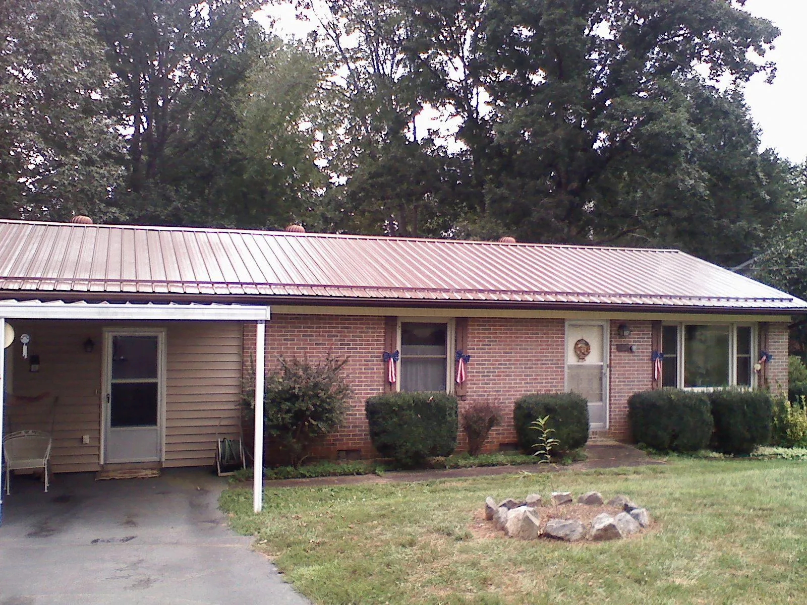 Bronze metal roof and carport on a brick ranch home — Roof Repair work by our crew in Orland Park